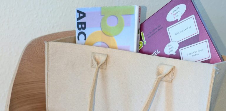 Holzplättchen mit Buchstaben liegen ungeordnet auf dem Tisch